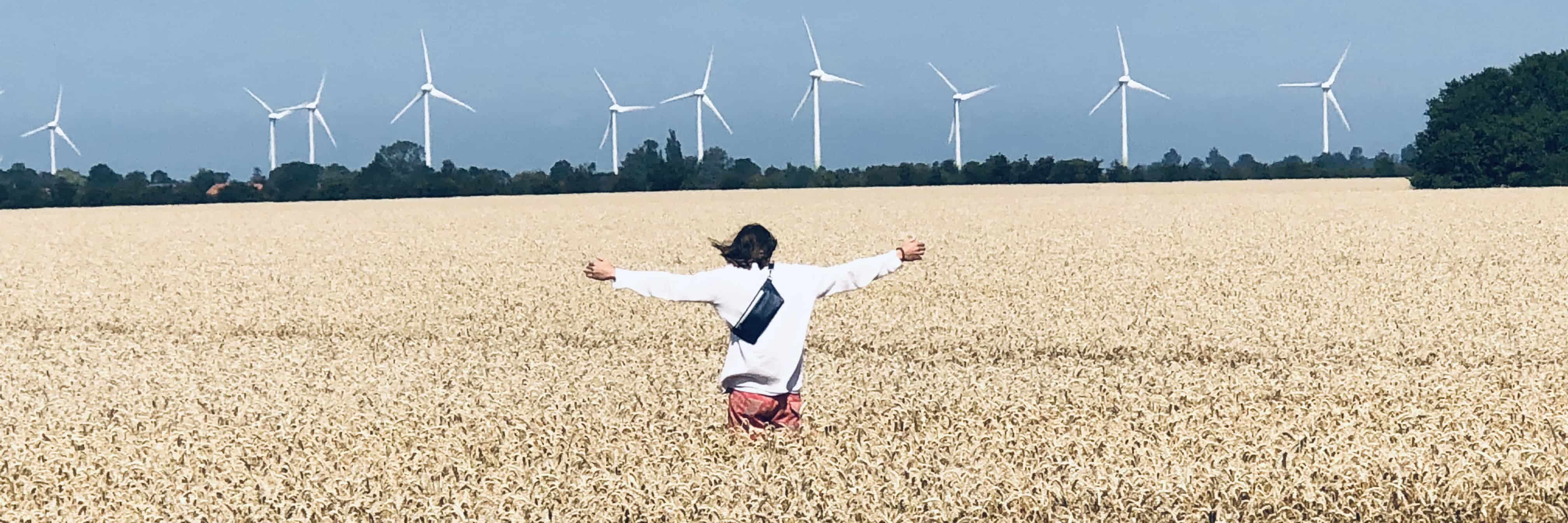 Standing in a Cornfield in front of wind turbines wearing the Manufabo Belt Bag